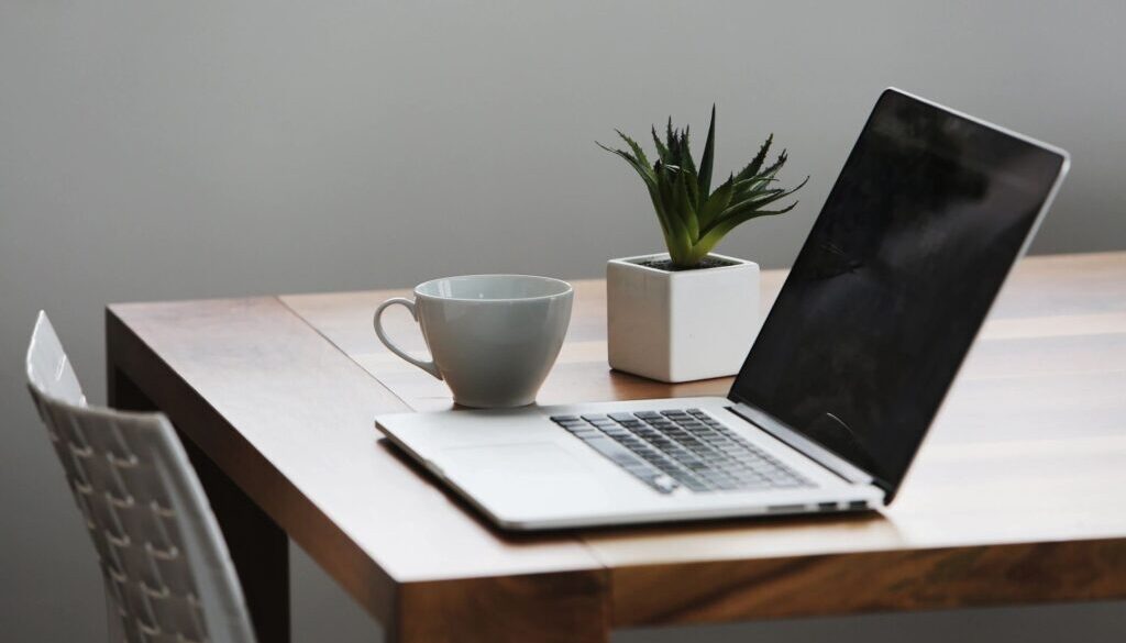 Laptop and cup on wooden table.