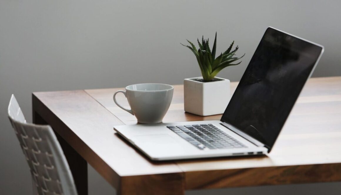 Laptop and cup on wooden table.