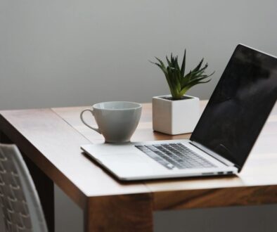 Laptop and cup on wooden table.